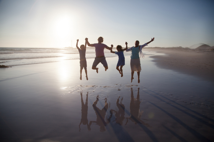 Family jumping together on a beach